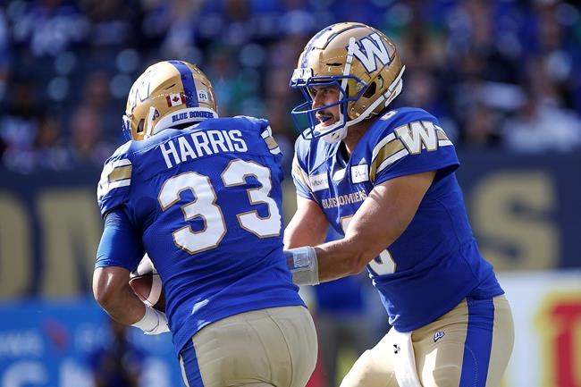 Winnipeg Blue Bombers quarterback Zach Collaros (8) hands off to Andrew Harris (33) against the Saskatchewan Roughriders during first half CFL action in Winnipeg, Saturday, Sept. 11, 2021. THE CANADIAN PRESS/John Woods