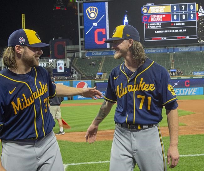 Milwaukee Brewers starter Corbin Burnes, left, and reliever Josh Hader celebrate after pitching a combined no-hitter against the Cleveland Indians in a baseball game in Cleveland, Saturday, Sept. 11, 2021. (AP Photo/Phil Long)