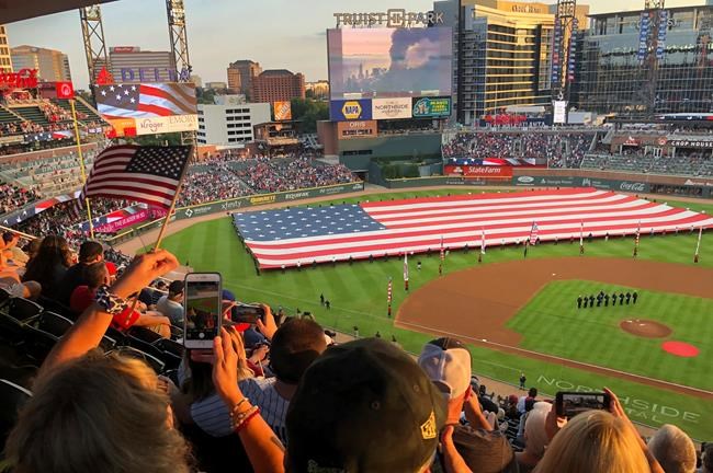Fans take photos during a pre-game ceremony in remembrance of the 9/11 attacks prior to a baseball game between the Atlanta Braves and the Miami Marlins on Saturday, Sept. 11, 2021, in Atlanta. (AP Photo/Ben Margot)