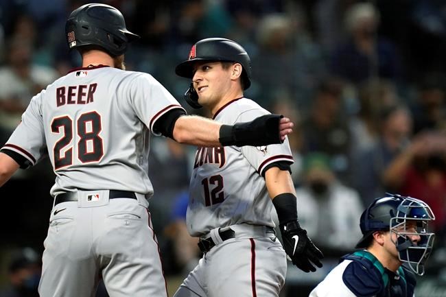 Arizona Diamondbacks' Daulton Varsho, center, is congratulated at home by Seth Beer (28) on Varsho's two-run home run against the Seattle Mariners during the fourth inning of a baseball game Saturday, Sept. 11, 2021, in Seattle. (AP Photo/Elaine Thompson)