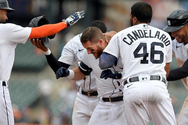 Detroit Tigers' Robbie Grossman, middle, is congratualted by teammates after walking in the winning run with the bases loaded against the Tampa Bay Rays in the eleventh inning of a baseball game, Sunday, Sept. 12, 2021, in Detroit. (AP Photo/Jose Juarez)