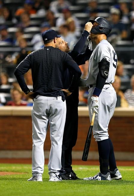 New York Yankees manager Aaron Boone checks on New York Yankees Aaron Judge during a time out against the New York Mets during the first inning of a baseball game on Sunday, Sept.12, 2021, in New York. (AP Photo/Noah K. Murray)
