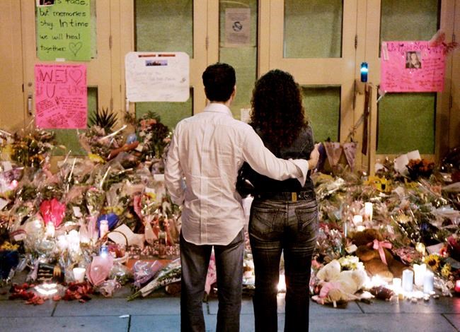 A couple observe a public memorial at the scene of the Dawson College shootings in the early morning of Sunday, Sept. 17, 2006. Survivors and families of Montreal's Dawson College shooting victims in Quebec are urging Canadians against voting for the Conservatives and party leader Erin O'Toole. THE CANADIAN PRESS/Ian Barrett