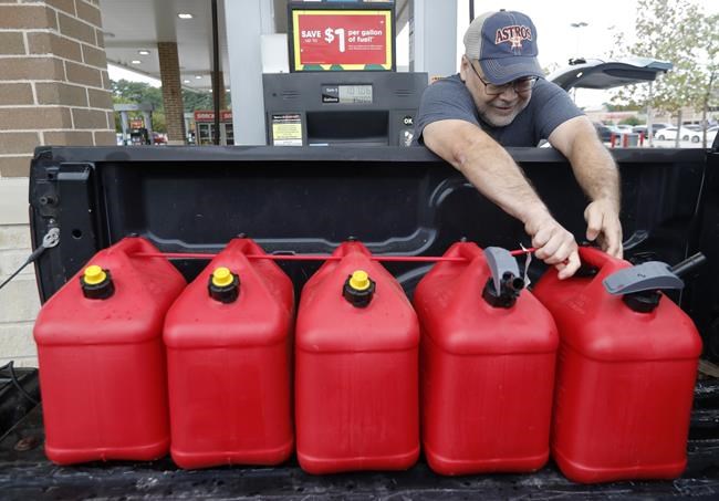 Paul Villagomez secures filled gas containers in his truck as he prepares for Tropical Storm Nicholas, Monday, Sept. 13, 2021, in Kingwood, Texas.
