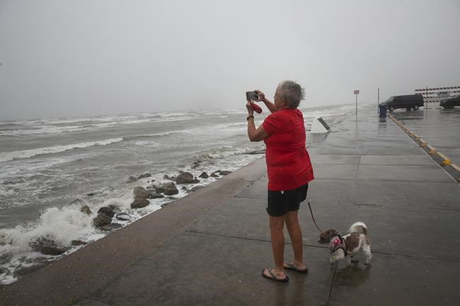 Cheri Daigle, una profesora jubilada, toma una fotografía mientras la tormenta tropical Nicholas se acerca a la costa de Texas, el lunes 13 de septiembre de 2021, en Galveston, Texas. (Jon Shapley/Houston Chronicle vía AP)