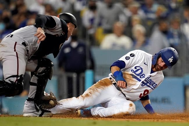 Los Angeles Dodgers' Gavin Lux, right, is tagged out at home plate by Arizona Diamondbacks catcher Carson Kelly after a sacrifice fly by Mookie Betts during the fourth inning of a baseball game Monday, Sept. 13, 2021, in Los Angeles. (AP Photo/Marcio Jose Sanchez)