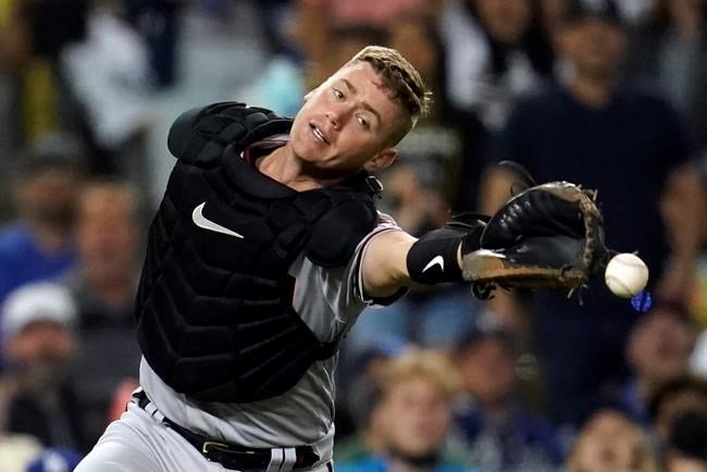 Arizona Diamondbacks catcher Carson Kelly reaches but cannot catch a foul ball from Los Angeles Dodgers' Cody Bellinger during the seventh inning of a baseball game Monday, Sept. 13, 2021, in Los Angeles. (AP Photo/Marcio Jose Sanchez)