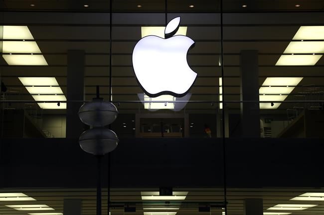 FILE - This Dec. 16, 2020 file photo shows an illuminated Apple logo at a store in Munich, Germany. Apple has released a critical software patch to fix a security vulnerability that researchers say could allow hackers to directly infect iPhones and other Apple devices without any user action. (AP Photo/Matthias Schrader, File)