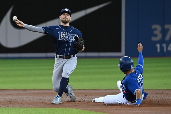 Tampa Bay Rays' Brandon Lowe, left, forces out Toronto Blue Jays' Marcus Semien at second base and throws to to first base to complete a double play on a ball hit by Blue Jays' Vladimir Guerrero Jr. in the first inning of an American League baseball game in Toronto on Tuesday, Sept. 14, 2021. THE CANADIAN PRESS/Jon Blacker