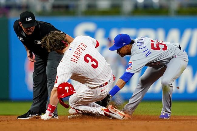 Philadelphia Phillies' Bryce Harper, center, slides into second for an RBI-double past the tag from Chicago Cubs shortstop Sergio Alcantara, right, during the sixth inning of a baseball game, Tuesday, Sept. 14, 2021, in Philadelphia. (AP Photo/Matt Slocum)