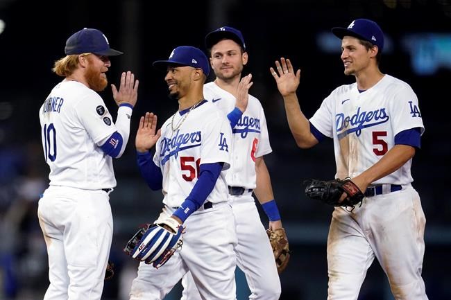 Los Angeles Dodgers' Justin Turner, Mookie Betts, Trea Turner and Corey Seager, from left, celebrate the team's 8-4 win over the Arizona Diamondbacks in a baseball game Tuesday, Sept. 14, 2021, in Los Angeles. (AP Photo/Marcio Jose Sanchez)