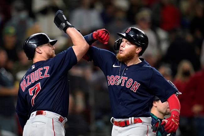 Boston Red Sox's Alex Verdugo, right, is greeted at the plate by Christian Vazquez on Verdugo's two-run home run against the Seattle Mariners during the eighth inning of a baseball game Tuesday, Sept. 14, 2021, in Seattle. (AP Photo/Elaine Thompson)