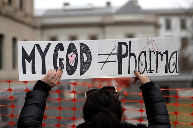 FILE - In this Jan. 13, 2020, file photo, a woman holds a sign during a protest at the state house in Trenton, N.J. Religious objections, once used only sparingly around the country to get exempted from various required vaccines, are becoming a much more widely used loophole against the COVID-19 shot. (AP Photo/Seth Wenig, File)