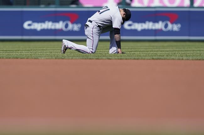 Miami Marlins' Miguel Rojas, wearing number 21 in honor of Roberto Clemente Day, kneels on the field before a baseball game against the Washington Nationals at Nationals Park, Wednesday, Sept. 15, 2021, in Washington. (AP Photo/Alex Brandon)