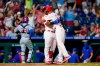 Philadelphia Phillies' Andrew Knapp, right, and Jean Segura celebrate after Knapp scored the game-winning run on a passed ball during the ninth inning of a baseball game against the Chicago Cubs, Wednesday, Sept. 15, 2021, in Philadelphia. (AP Photo/Matt Slocum)
