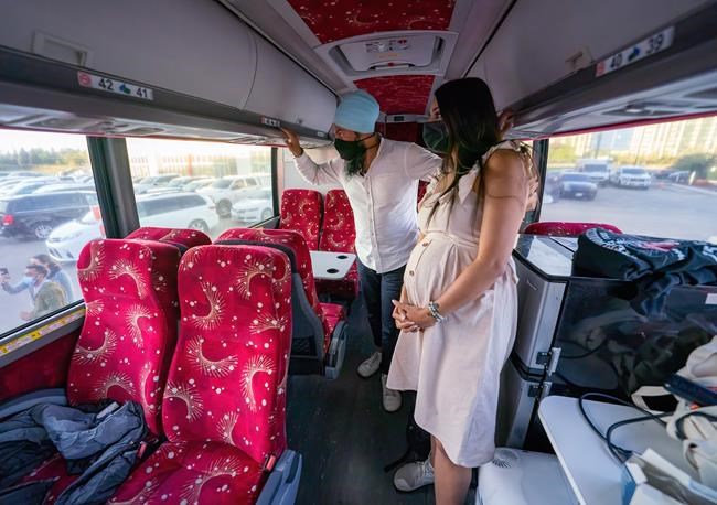 NDP Leader Jagmeet Singh and his wife Gurkiran Kaur Sidhu wait on their campaign bus to be introduced to a crowd at a campaign stop in Brampton, Ont. Wednesday, Sept. 15, 2021. THE CANADIAN PRESS/Jonathan Hayward