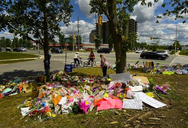 A woman visits the scene and a tribute to the victims of the deadly vehicle attack on five members of the Canadian Muslim community in London, Ont., on Monday, June 14, 2021. Many Muslim Canadians have shared feelings of anxiety after four members of a Muslim family out for an evening stroll were struck and killed by a vehicle in London, Ont., in what police have called an attack motivated by hate. THE CANADIAN PRESS/Nathan Denette