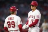 Los Angeles Angels designated hitter Shohei Ohtani (17) talks with first base coach Bruce Hines (99) at first base during the first inning of a baseball game against the Oakland Athletics Friday, Sept. 17, 2021, in Anaheim, Calif. (AP Photo/Ashley Landis)