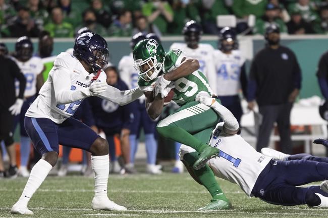 Saskatchewan Roughriders running back William Powell (29) runs the ball as Toronto Argonauts defensive back Shaquille Richardson (1) and defensive back Jamal Peters (12) defend during the first half of CFL football action in Regina on Friday, September 17, 2021. THE CANADIAN PRESS/Kayle Neis