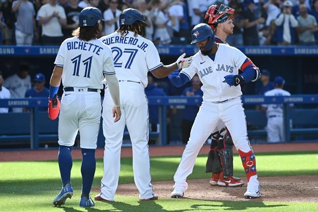 Toronto Blue Jays' Teoscar Hernandez, right, celebrates with Bo Bichette (11) and Vladimir Guerrero Jr. (37) after hitting a three-run home run in the fourth inning of an American League baseball game against the Minnesota Twins in Toronto on Saturday, Sept. 18, 2021. THE CANADIAN PRESS/Jon Blacker