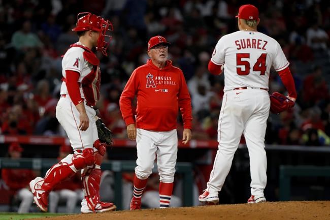 Los Angeles Angels manager Joe Maddon, center, walks to the mound to remove starting pitcher Jose Suarez, right, during the sixth inning of the team's baseball game against the Oakland Athletics in Anaheim, Calif., Saturday, Sept. 18, 2021. At left is catcher Max Stassi. (AP Photo/Alex Gallardo)