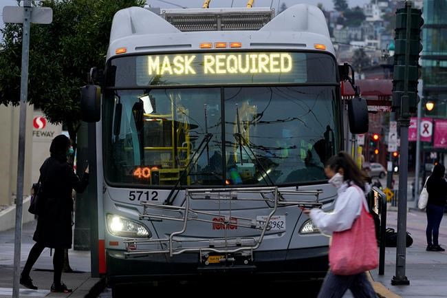 FILE - In this Tuesday, Nov. 17, 2020 file photo, a sign on a Muni bus in San Francisco advises that passengers are required to wear masks, during the coronavirus pandemic. (AP Photo/Jeff Chiu, File)