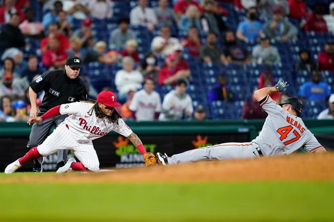 Philadelphia Phillies third baseman Freddy Galvis, left, tags out Baltimore Orioles' John Means at third after Means tried to advance on a passed ball during the seventh inning of an interleague baseball game, Monday, Sept. 20, 2021, in Philadelphia. (AP Photo/Matt Slocum)