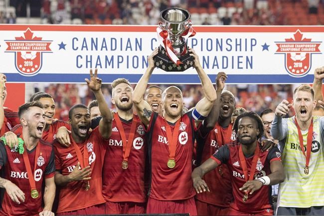 Toronto FC captain Michael Bradley lifts the Voyageurs Cup after beating Vancouver Whitecaps 5-2 to win the Canadian Championship Final in Toronto on Wednesday, August 15, 2018. THE CANADIAN PRESS/Chris Young