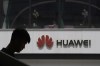 FILE - In this Thursday, May 16, 2019 file photo, a man is silhouetted near the Huawei logo in Beijing. Lithuanian cybersecurity authorities are urging the country’s governmental agencies to abandon the use of Chinese smartphone brands. Lithuania’s National Cyber Security Center said Tuesday, Sept. 21, 2021 it found four major cybersecurity risks for devices made by Huawei and Xiaomi. (AP Photo/Ng Han Guan, file)