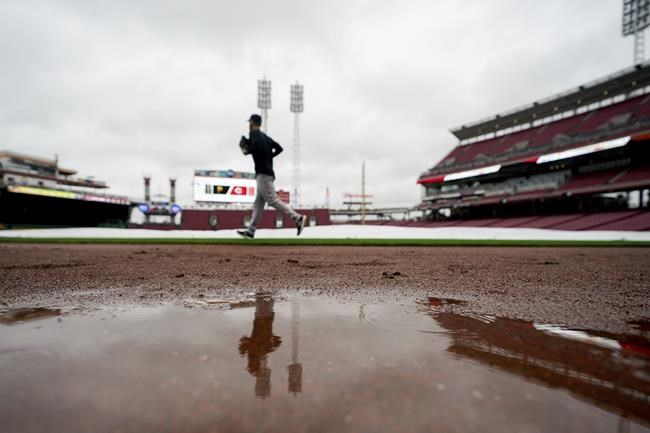 Pittsburgh Pirates' starting pitcher Chad Kuhl (39) runs past the tarp covered field prior to a baseball game against the Cincinnati Reds in Cincinnati, Wednesday, Sept 22, 2021. (AP Photo/Bryan Woolston)