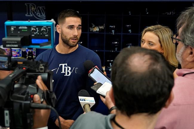 Tampa Bay Rays' Kevin Kiermaier, left, talks to reporters before a baseball game against the Toronto Blue Jays Wednesday, Sept. 22, 2021, in St. Petersburg, Fla. Kiermaier was answering questions about him picking up the Blue Jays pitch data card after being tagged out at home plate by catcher Alejandro Kirk during Monday's game. (AP Photo/Chris O'Meara)