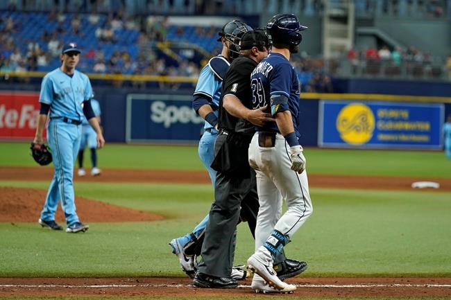 Tampa Bay Rays' Kevin Kiermaier, right, is held back by home plate umpire Bruce Dreckman and Toronto Blue Jays catcher Danny Jansen after Kiermaier was hit with a pitch by starting pitcher Ryan Borucki, right, during the eighth inning of a baseball game Wednesday, Sept. 22, 2021, in St. Petersburg, Fla. (AP Photo/Chris O'Meara)