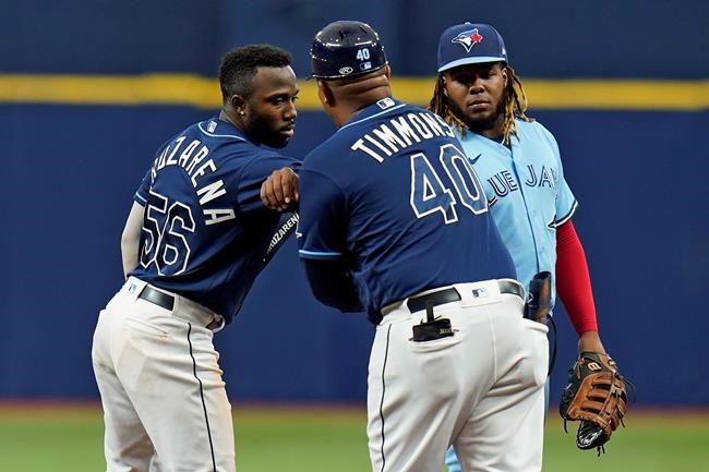 Tampa Bay Rays' Randy Arozarena (56) celebrates with first base coach Ozzie Timmons (40) after his double off Toronto Blue Jays pitcher Ross Stripling during the third inning of a baseball game Wednesday, Sept. 22, 2021, in St. Petersburg, Fla. Looking on is Blue Jays' Vladimir Guerrero Jr.(AP Photo/Chris O'Meara)