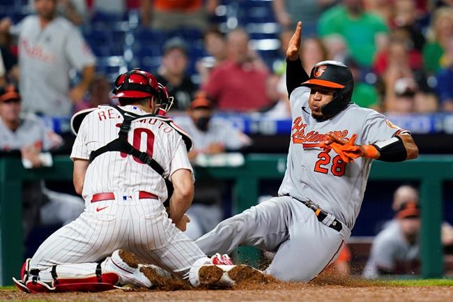 Baltimore Orioles' Pedro Severino, right, is tagged out at home by Philadelphia Phillies catcher J.T. Realmuto after trying to score on a single by Pat Valaika during the eighth inning of an interleague baseball game, Wednesday, Sept. 22, 2021, in Philadelphia. (AP Photo/Matt Slocum)