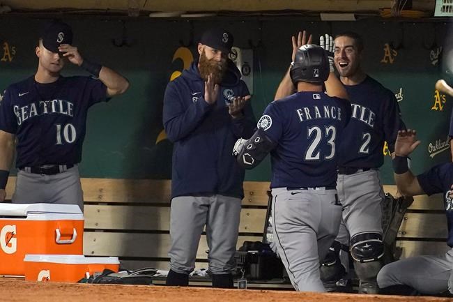 Seattle Mariners' Ty France (23) is congratulated by teammates after hitting a home run against the Oakland Athletics during the fifth inning of a baseball game in Oakland, Calif., Wednesday, Sept. 22, 2021. (AP Photo/Jeff Chiu)
