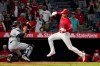 Los Angeles Angels designated hitter Shohei Ohtani, right, avoids a tag by Houston Astros catcher Jason Castro but misses the plate during the 10th inning of a baseball game Wednesday, Sept. 22, 2021, in Anaheim, Calif. Ohtani was later tagged out by Castro. (AP Photo/Mark J. Terrill)