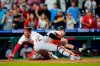 Philadelphia Phillies' Bryce Harper, left, scores the game-winning run past Baltimore Orioles catcher Austin Wynns on a two-run triple by J.T. Realmuto during the 10th inning of an interleague baseball game, Tuesday, Sept. 21, 2021, in Philadelphia. (AP Photo/Matt Slocum)