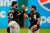 Chicago White Sox's Leury Garcia (28) and Yoan Moncada (10) celebrate after defeating the Cleveland Indians in the first baseball game of a doubleheader, Thursday, Sept. 23, 2021, in Cleveland. The White Sox clinched the American League Central title with the win. (AP Photo/Tony Dejak)