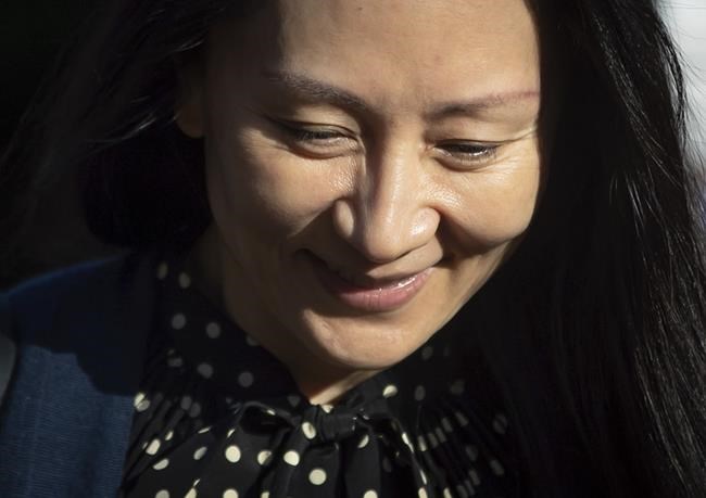 Meng Wanzhou, centre, chief financial officer of Huawei, leaves her home in Vancouver, on Friday, Sept. 24, 2021. U.S. prosecutors are prepared to resolve criminal charges against the chief financial officer of Chinese communications giant Huawei Technologies, the Justice Department disclosed Friday in a letter to a federal judge in New York. (Darryl Dyck/The Canadian Press via AP)
