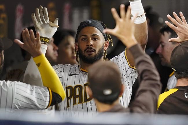San Diego Padres' Fernando Tatis Jr. reacts with teammates after hitting a home run during the seventh inning of a baseball game against the Atlanta Braves, Friday, Sept. 24, 2021, in San Diego. (AP Photo/Gregory Bull)