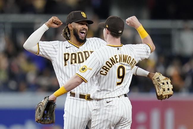 San Diego Padres shortstop Fernando Tatis Jr., left, celebrates with second baseman Jake Cronenworth after the Padres defeated the Atlanta Braves 6-5 in the resumption of a baseball game Friday, Sept. 24, 2021, in San Diego. The game was originally played July 21, 2021, but was suspended in the middle of the fifth inning due to rain.(AP Photo/Gregory Bull)