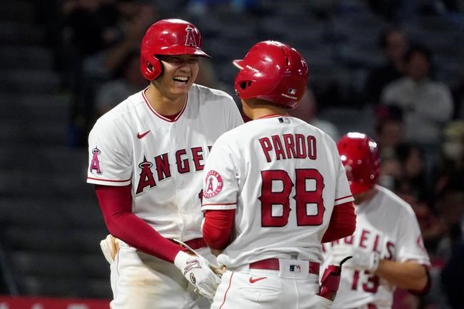 Los Angeles Angels designated hitter Shohei Ohtani, right, laughs at the bat boy after being intentionally walked during the ninth inning of a baseball game against the Seattle Mariners Friday, Sept. 24, 2021, in Anaheim, Calif. (AP Photo/Mark J. Terrill)