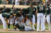 Oakland Athletics teammates attend to Elvis Andrus, center, as he collapsed with an injury after scoring against the Houston Astros in the ninth inning of a baseball game in Oakland, Calif., Saturday, Sept. 25, 2021. The Athletics won 2-1. (AP Photo/John Hefti)