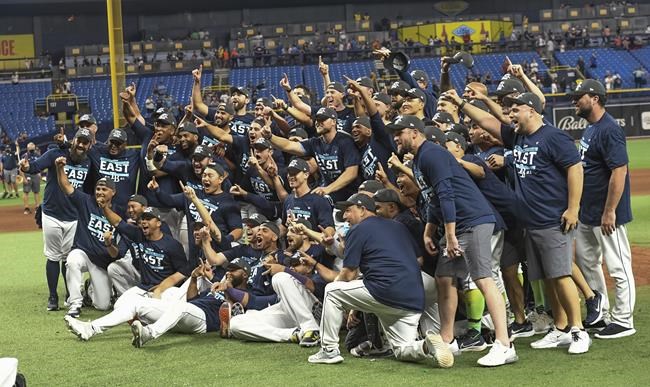 Tampa Bay Rays players and coaches celebrate after beating the Miami Marlins 7-3 to clinch the American League East during a baseball game Saturday, Sept. 25, 2021, in St. Petersburg, Fla. (AP Photo/Steve Nesius)