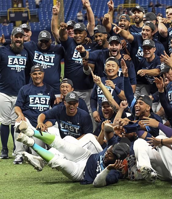 Tampa Bay Rays' Randy Arozarena dives into the gathering of players and coaches as they celebrate after defeating the Miami Marlins 7-3 to clinch the American League East during a baseball game Saturday, Sept. 25, 2021, in St. Petersburg, Fla. (AP Photo/Steve Nesius)