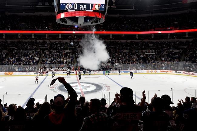 Winnipeg Jets' fans cheer after the Jets scored during first period NHL preseason action against the Ottawa Senators, in Winnipeg, Sunday, Sept. 26, 2021. THE CANADIAN PRESS/Fred Greenslade