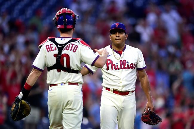 Philadelphia Phillies starting pitcher Ranger Suarez, right, is congratulated by J.T. Realmuto after their victory over the Pittsburgh Pirates, Saturday, Sept. 25, 2021, in Philadelphia. (AP Photo/Derik Hamilton)