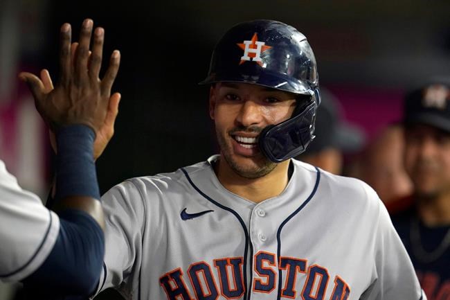 Houston Astros' Carlos Correa is greeted in the dugout after scoring on a two-run home run by Kyle Tucker during the second inning of a baseball game against the Los Angeles Angels Tuesday, Sept. 21, 2021, in Anaheim, Calif. (AP Photo/Marcio Jose Sanchez)