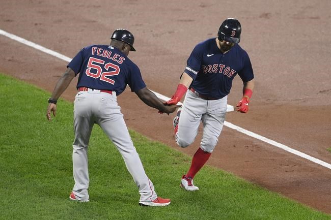Boston Red Sox' Kyle Schwarber, right, is greeted by third base coach Carlos Febles (52) as he rounds the bases on his home run during the second inning of a baseball game against the Baltimore Orioles, Tuesday, Sept. 28, 2021, in Baltimore. (AP Photo/Nick Wass)
