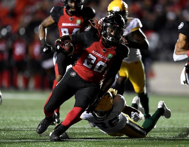 Ottawa Redblacks running back Timothy Flanders (20) evades the tackle of Edmonton Elks defensive back Aaron Grymes (36) during first half CFL football action in Ottawa on Tuesday, Sept. 28, 2021. THE CANADIAN PRESS/Justin Tang